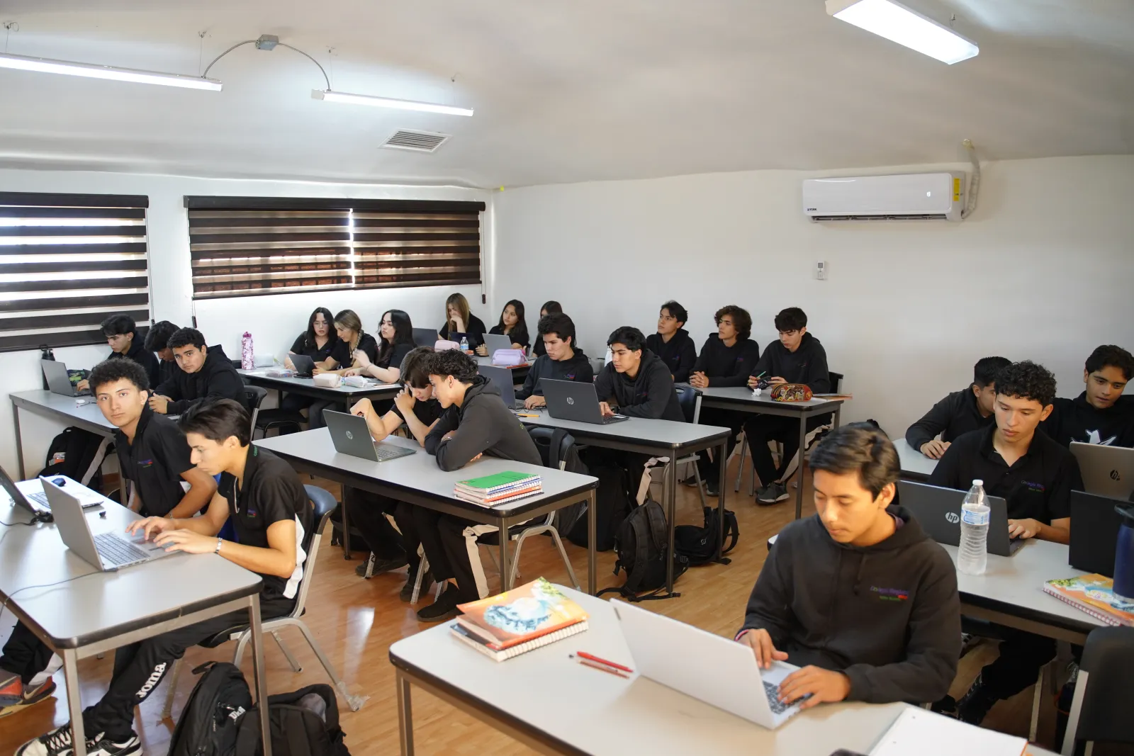 Alumnos de secundaria del CRB trabajando con laptops en el salón de clases